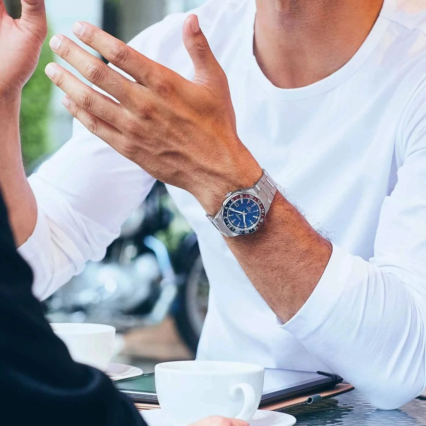Herrarmbandsur på handleden: blå urtavla och armband i rostfritt stål i affärslook
