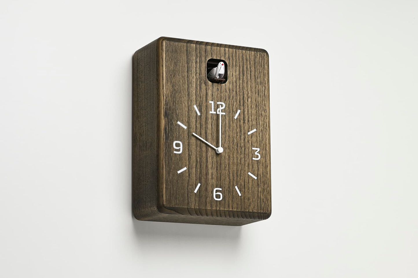 Wanduhr dunkelbraun aus Holz, seitlich mit Aufsatz oben und Analogziffern