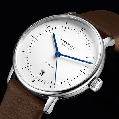 Herrklocka, närbild: vit urtavla med blå tim- och minutvisare, brunt läderarmband