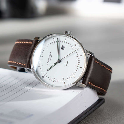 Armbandsur med brunt läderarmband, silverfärgat hölje och vit urtavla