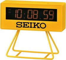 Gelber digitaler LCD-Wecker mit Stativ, Anzeige und SEIKO-Schriftzug.