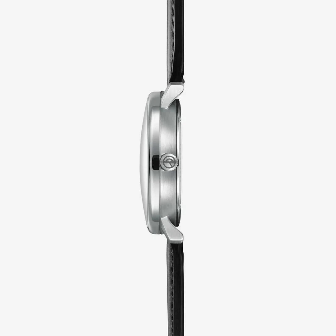 "Herrklocka från sidan: silverfärgat stålhölje, krona och svart läderarmband."