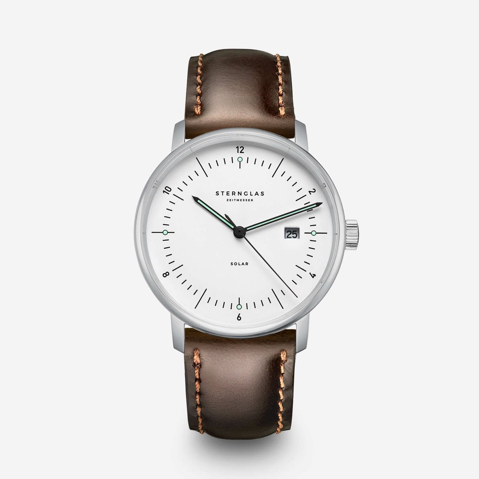 Klocka med mörkbrunt läderarmband, runt silverfärgat hölje och vit urtavla.