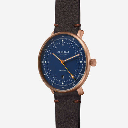 Herrklocka med blå urtavla, roséguldigt boett och brunt läderarmband.