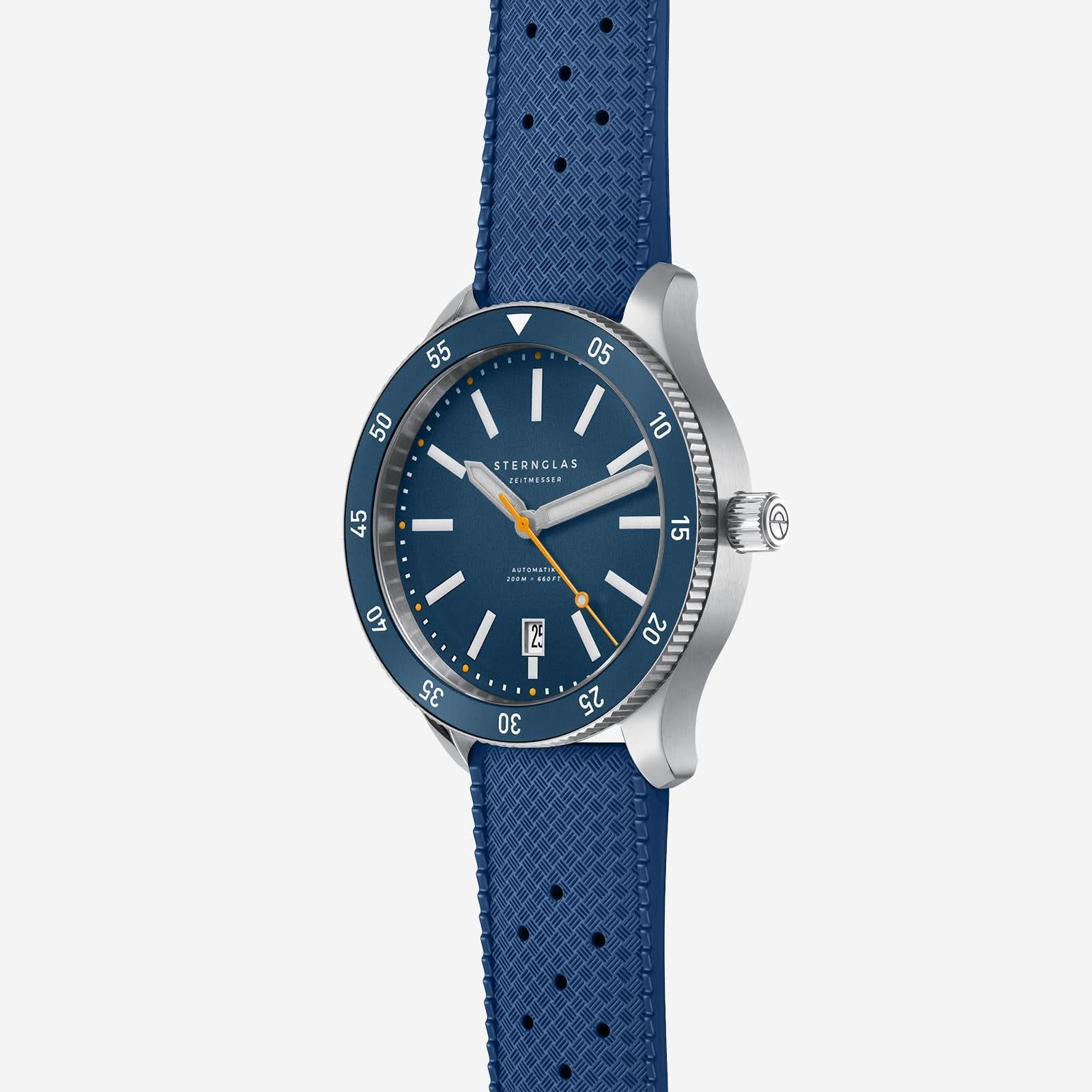 Herrklocka med blå urtavla, datumfönster vid 12 och blått armband.