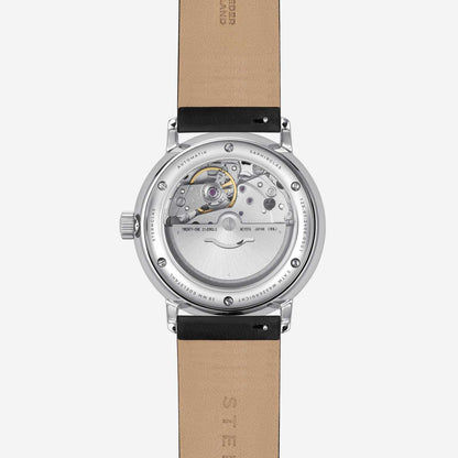 Herrklocka med öppen boett och synligt urverk, beige läderarmband.