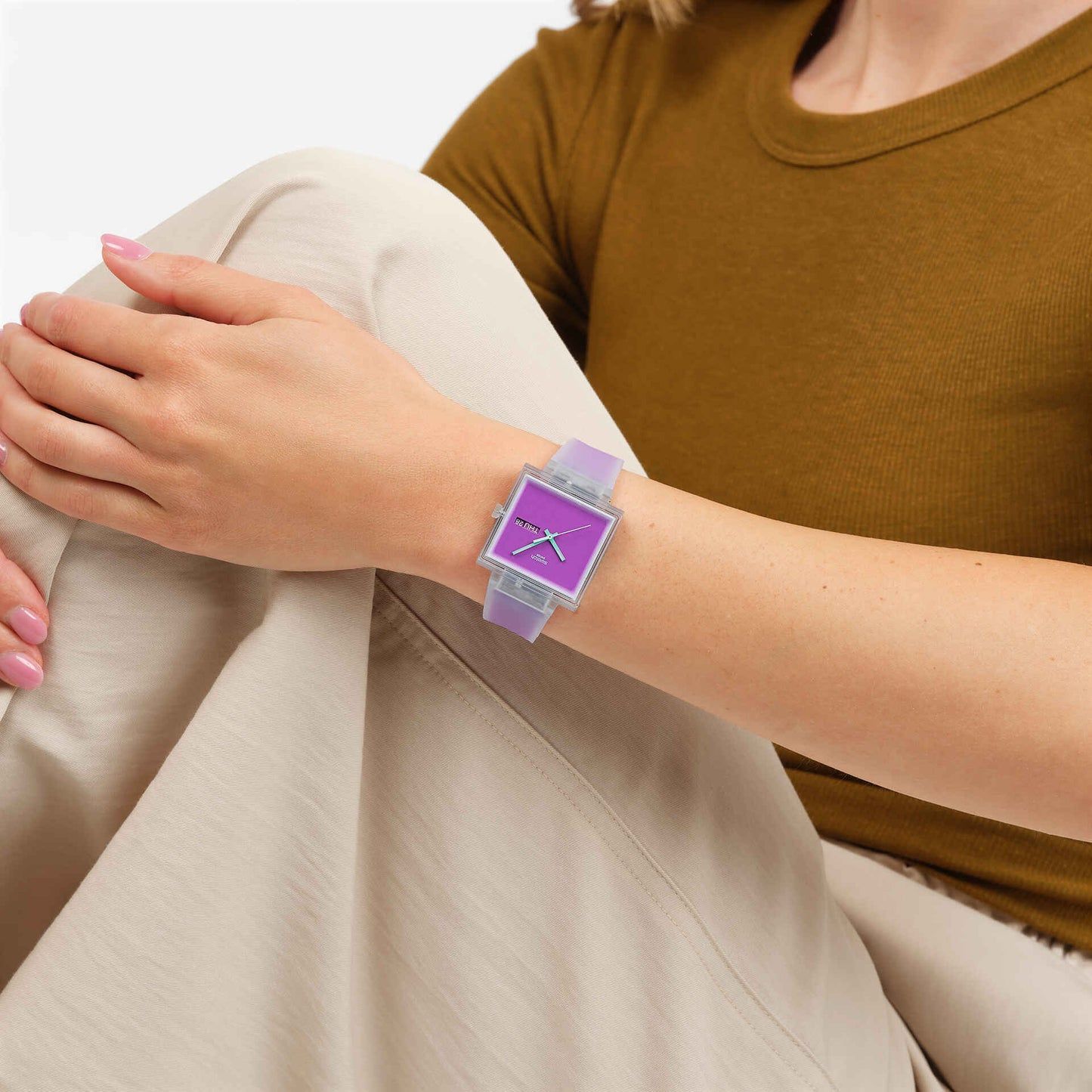 Swatch Armbanduhr am Handgelenk mit transparentem Band und violettem Zifferblatt