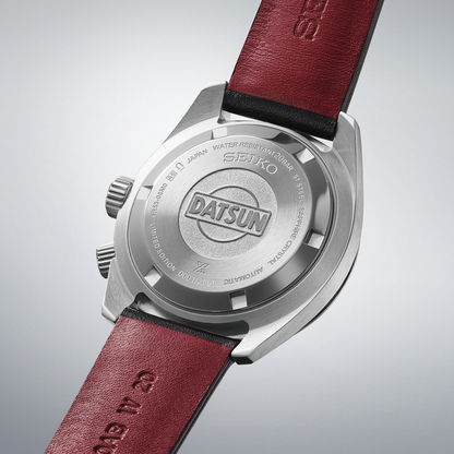 Seiko Prospex herrur med graverad botten, Datsun-logotyp och brunt/rött läderarmband.