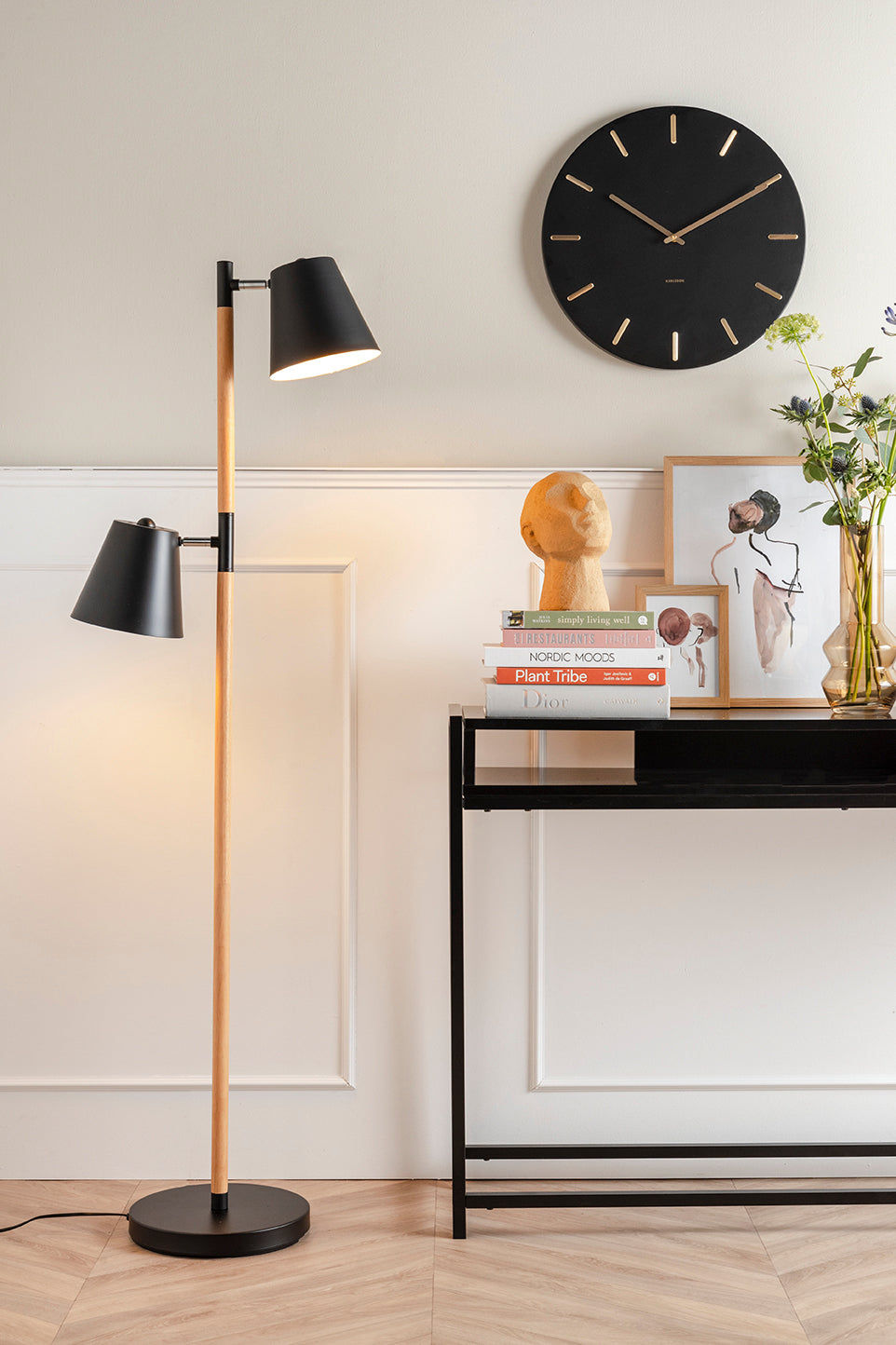 Väggklocka med svart urtavla och guldfärgade visare, rund design