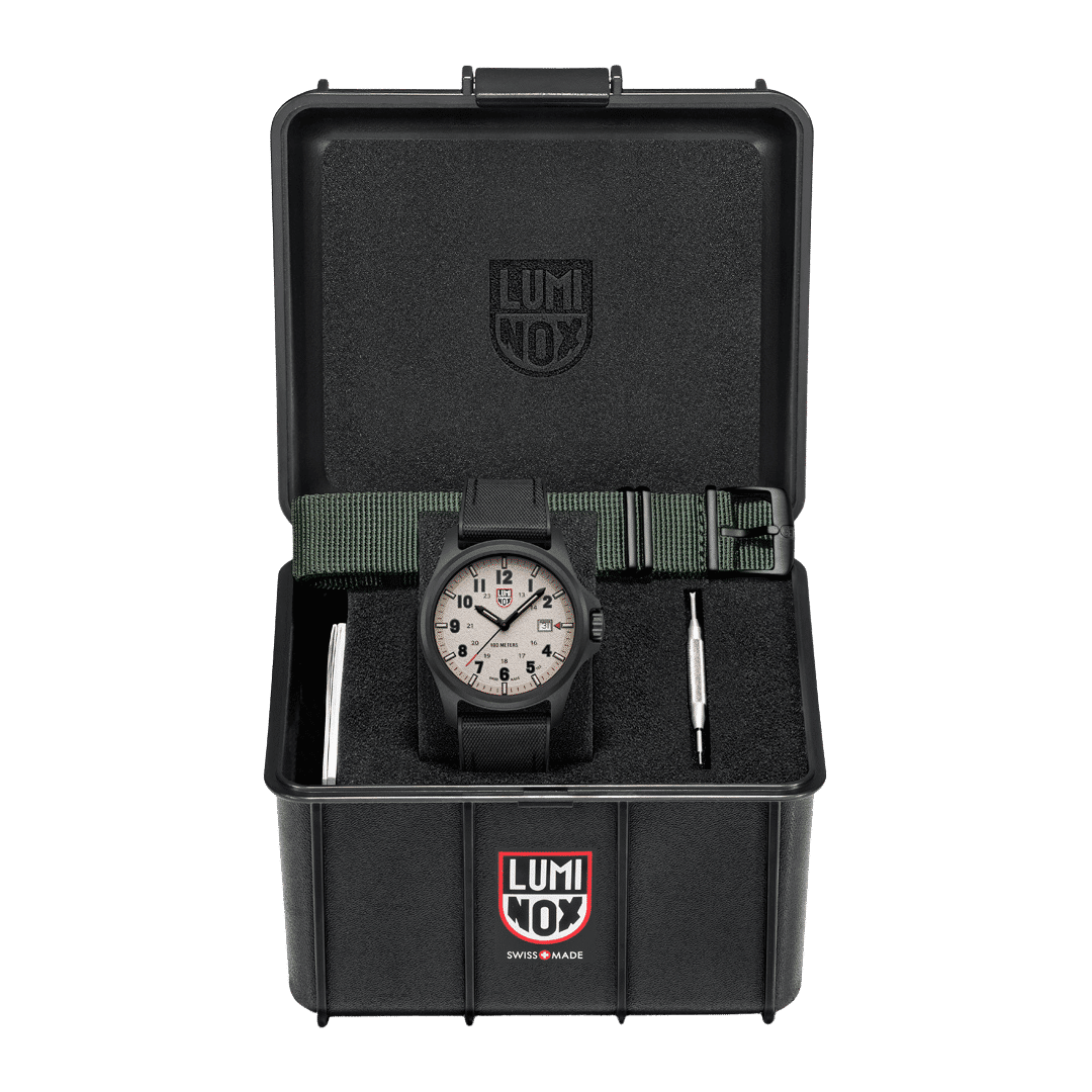 Herrklocka i svart förvaringsetui, synligt svart boett och textilarmband.