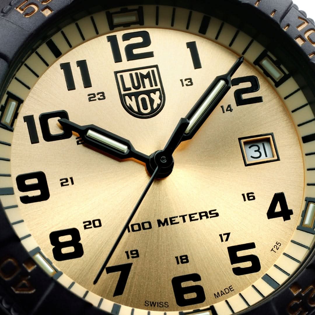 Närbild av urtavla: beige design, LUMINOX-logotyp, datum vid 3 och svarta visare