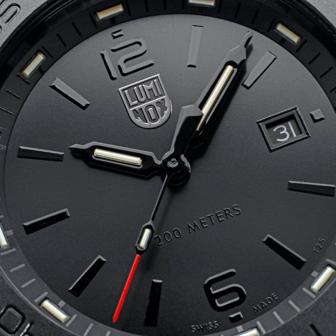 Luminox urtavla detaljer: logotyp, index och "200 METERS" gravyr; svart yta.