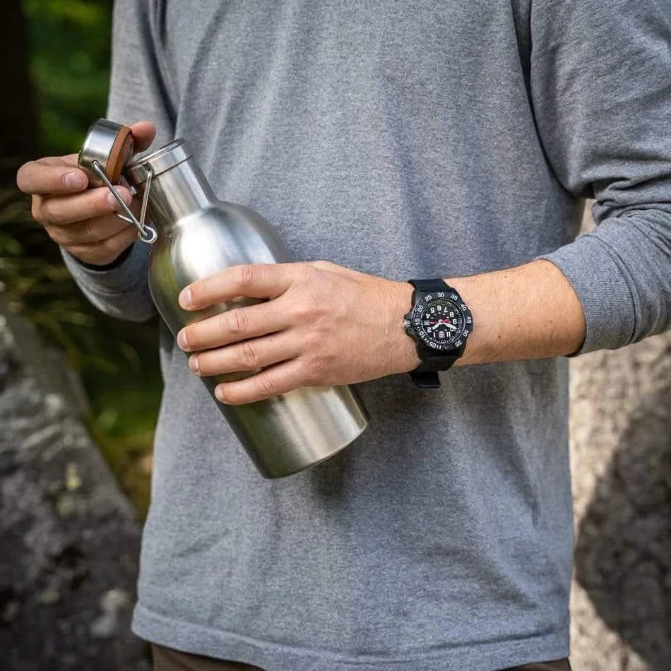 Herrklocka på handleden med svart armband och rund urtavla.
