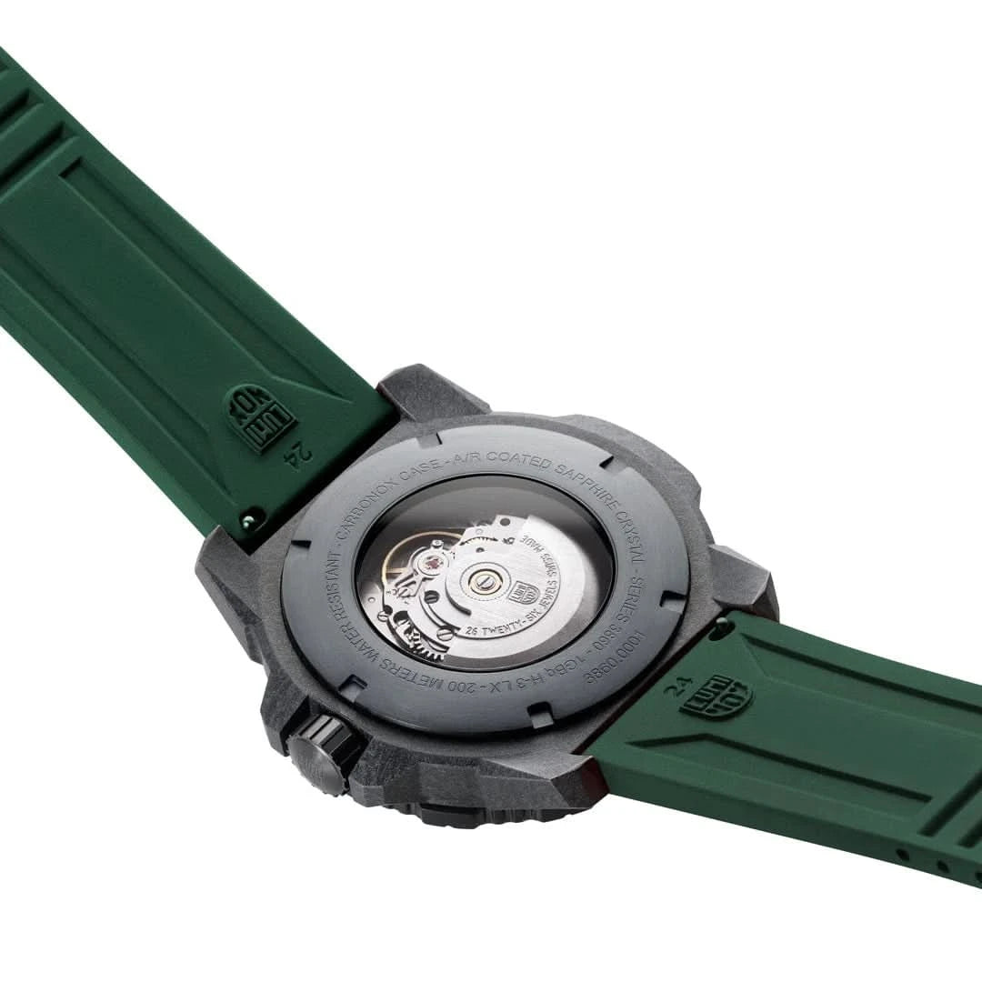 Herrklocka baksida: infälld boett med mekanikdetalj och grönt armband med säkerhetsspänne.