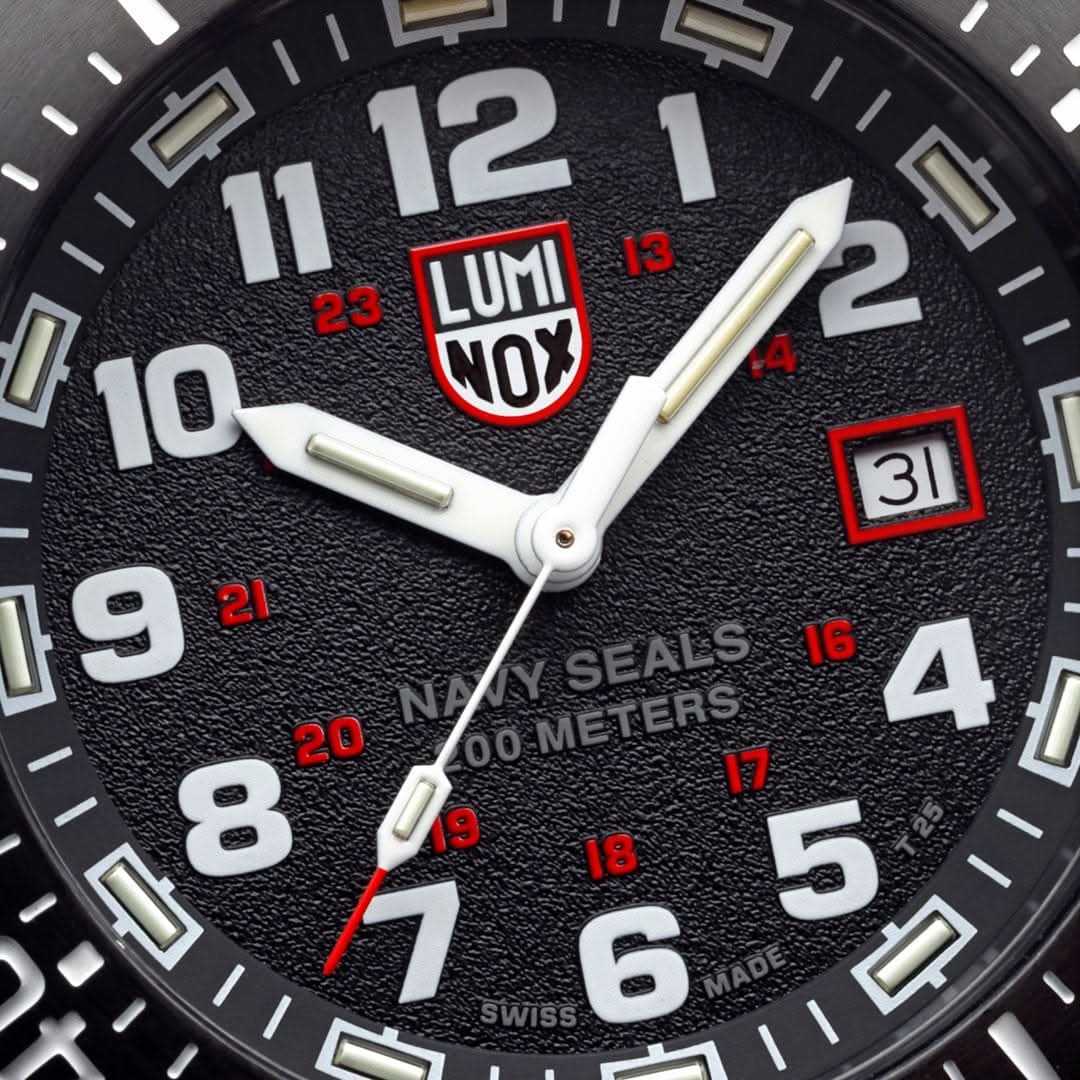Luminox urtavla med LUMINOX-NOX-logotyp, röda index och datumfönster vid 3