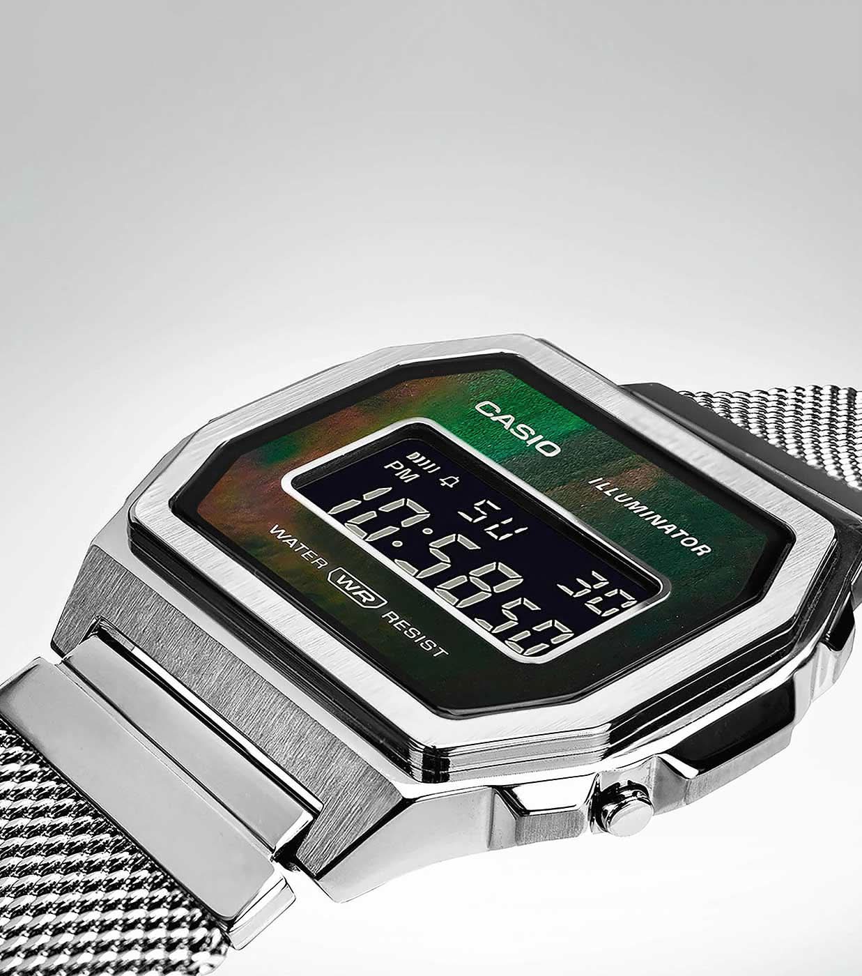 Digital klocka med silverfärgat hölje och grön LCD-display, meshband i blickfånget