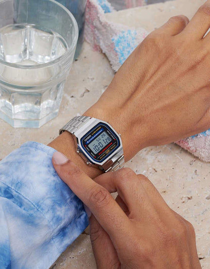Casio digital klocka på handleden med silverfärgat metallband och blå LCD-display