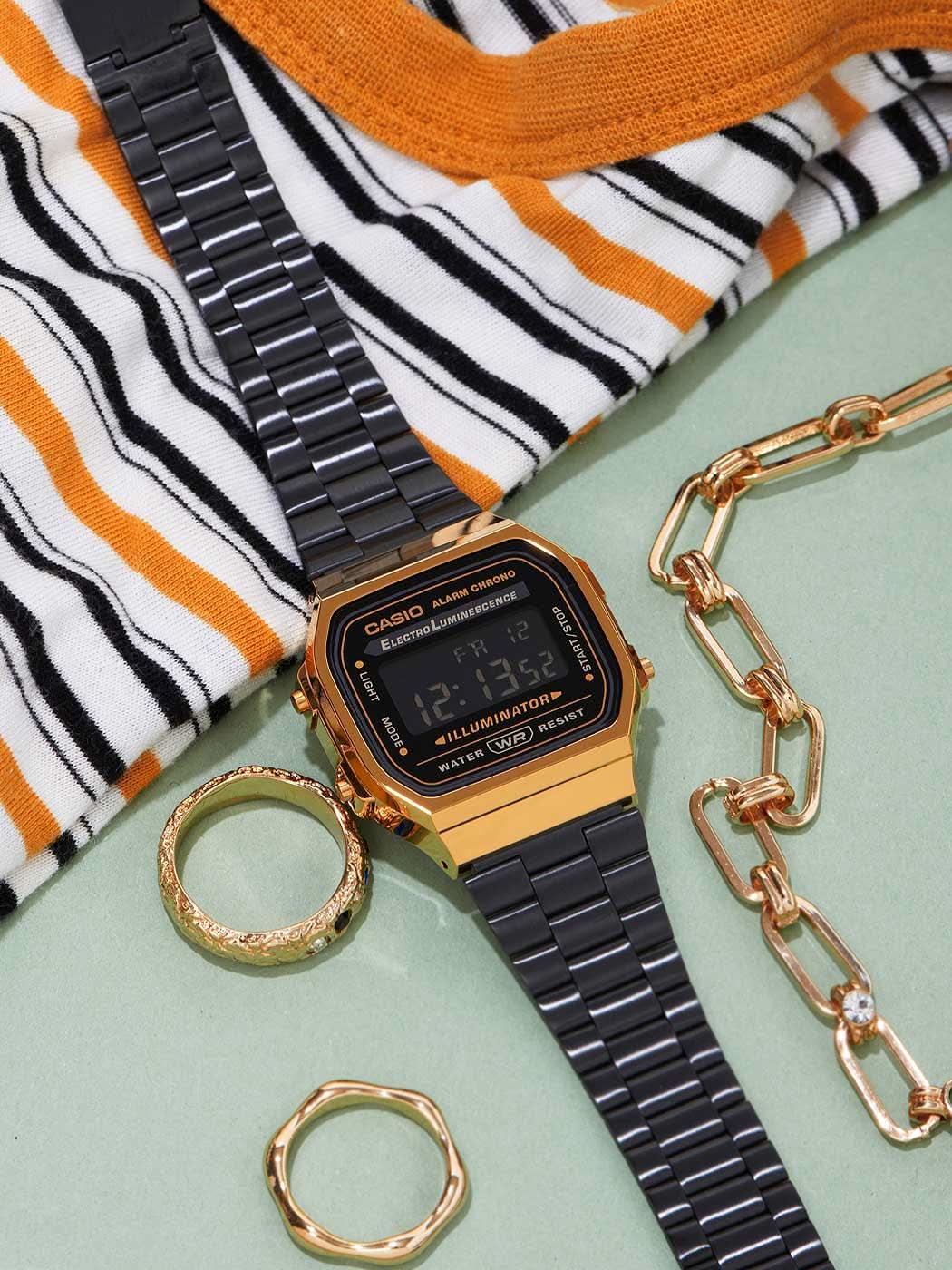 Digital vintageklocka med guldfärgad boettring och svart metallarmband