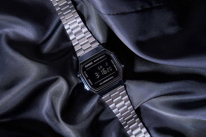Casio Vintage-klocka med silverfärgat metallarmband och svart digital display, buren i vinkel