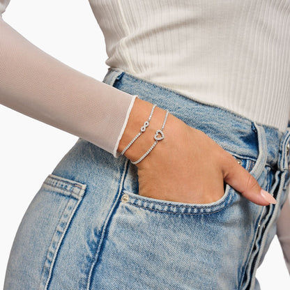 Tennisarmband runt handleden: silverfärgat kedjearmband med infinity-symbol och vita zirkoniastenar