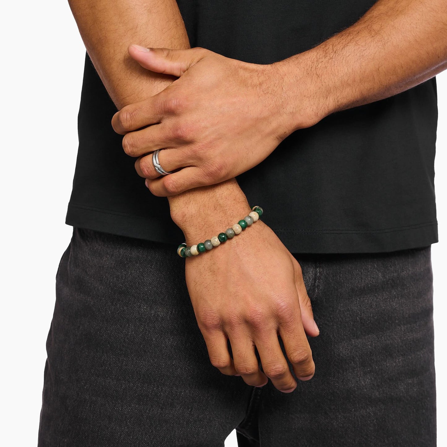 Armband av stenpärlor på handleden med gröna och beige kulpärlor