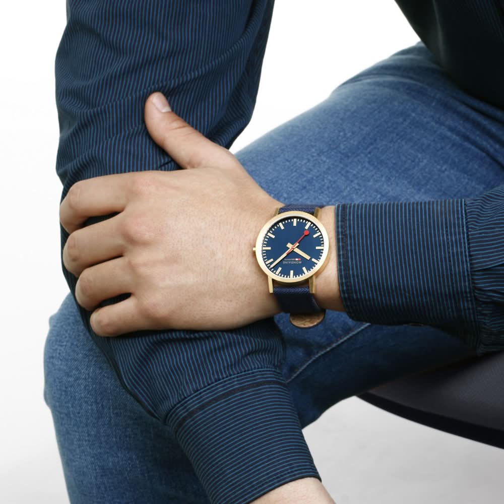 Armbandur på handleden med blå urtavla och mörkblått armband