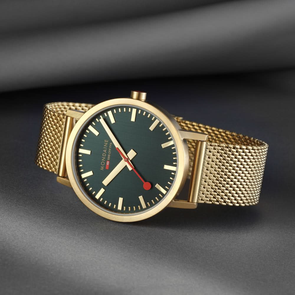 Guldpläterad herrklocka med mörkgrön urtavla, röda visare och mesh-armband