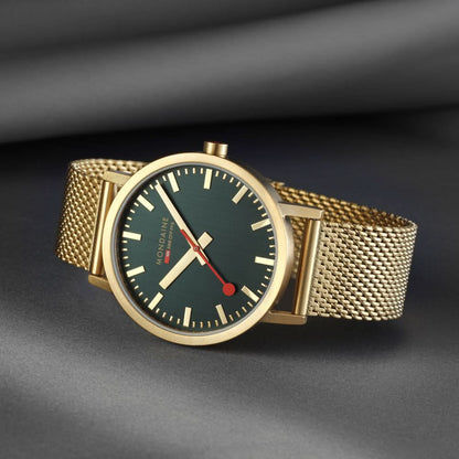 Guldpläterad herrklocka med mörkgrön urtavla, röda visare och mesh-armband