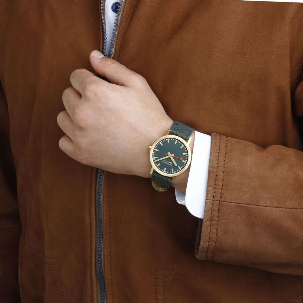 Unisex-armbandsur på handleden med mörkgrön urtavla och mörkgrönt tygband.