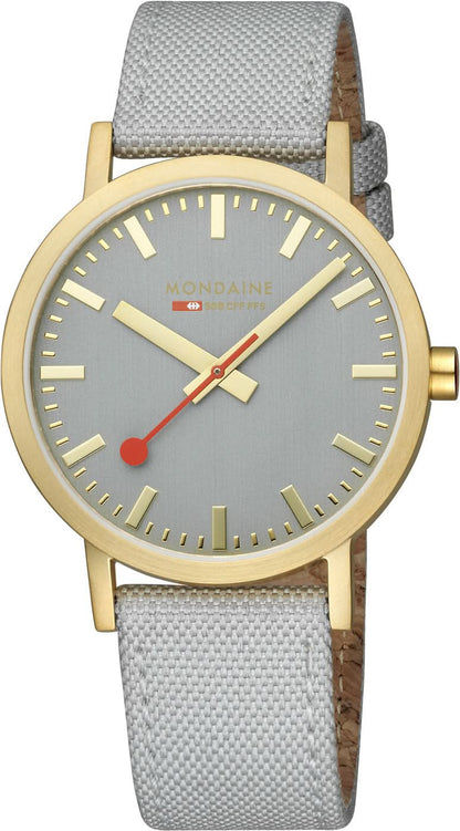 Unisex-armbandsur med ljusgrå urtavla, guldfärgad krona och grått tygband.