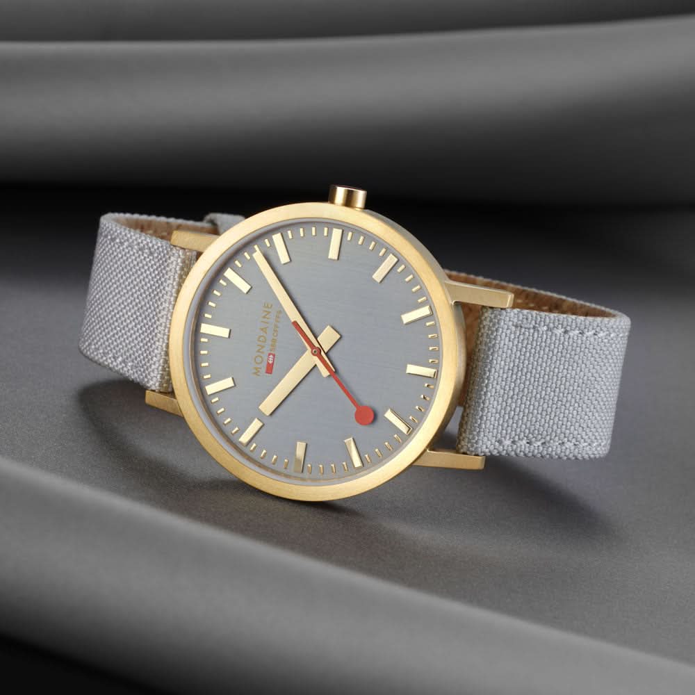 Unisex-armbandsur med ljusgrå urtavla, guldfärgad infattning, röda visare, grått band.