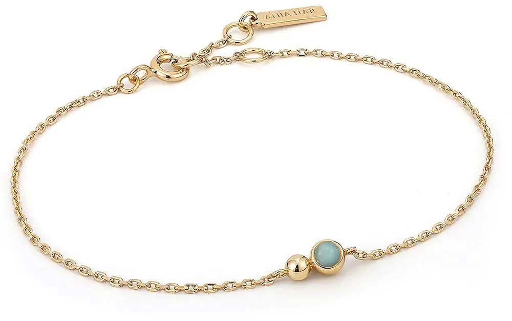 Guldfärgat armband med kedjelänkar, små kulhängen och en blå smyckessten