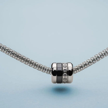Charm i rostfritt stål med zirkoniaband, svart mittdel och kuldesign på kedja