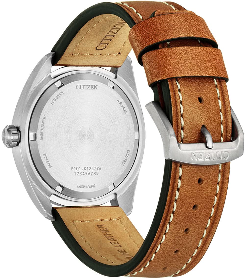 Armbandsur med brunt läderarmband, boett i rostfritt stål, synliga öglor och gravyr