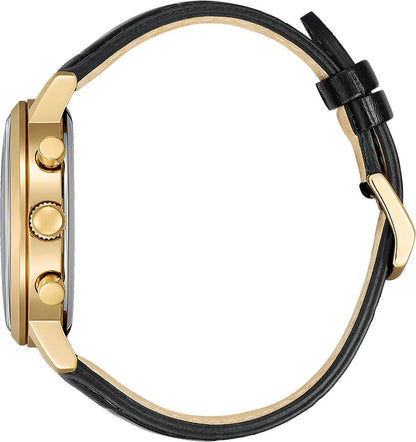 Sidovy av ett klockfodral med guldfärgad infattning och krona, fäst svart läderarmband