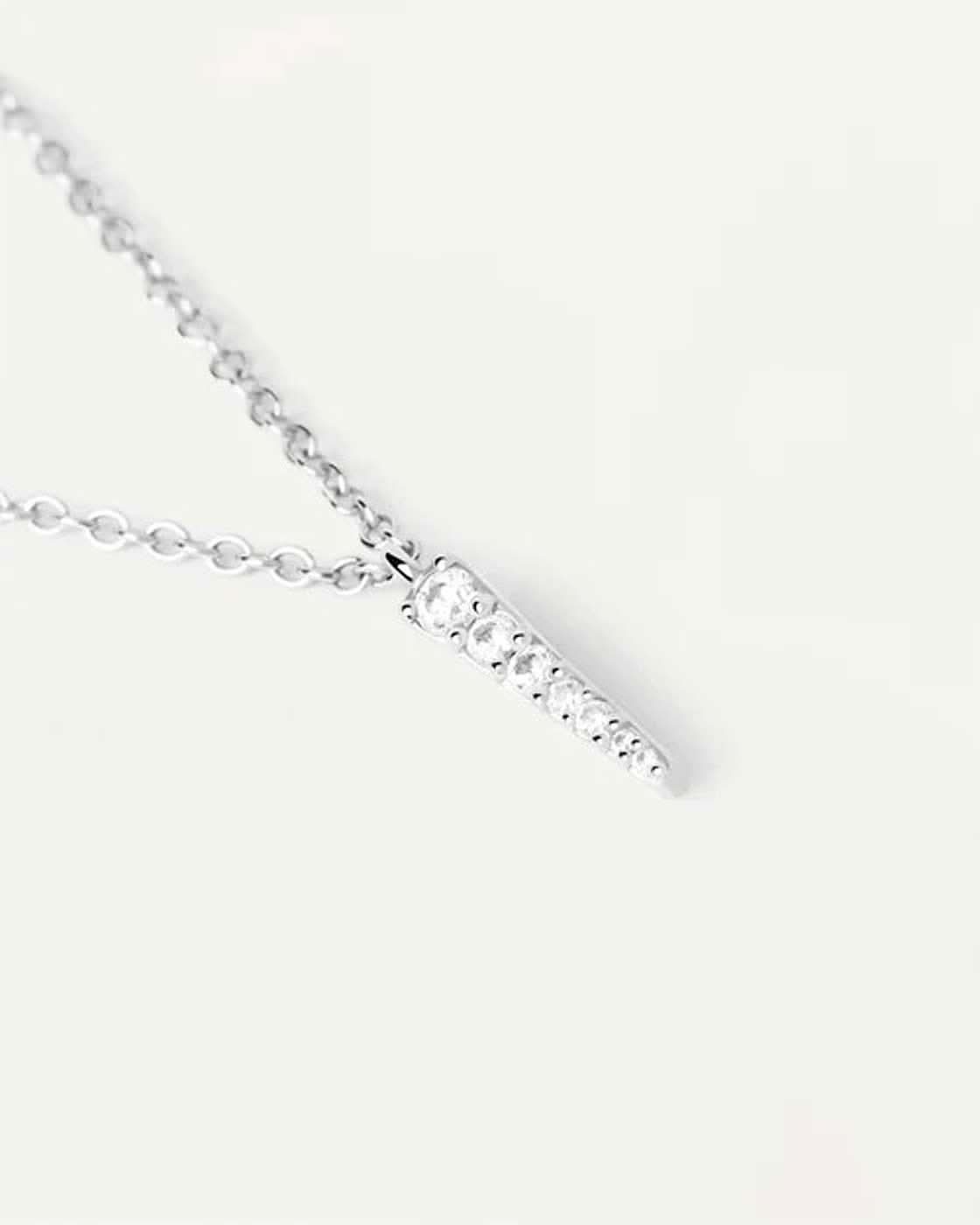 Närbild: spetsig hängsmycke i sterlingsilver med små stenar
