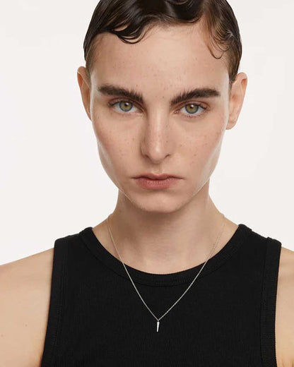Halsband i sterlingsilver runt halsen med ett smalt, spetsigt hänge