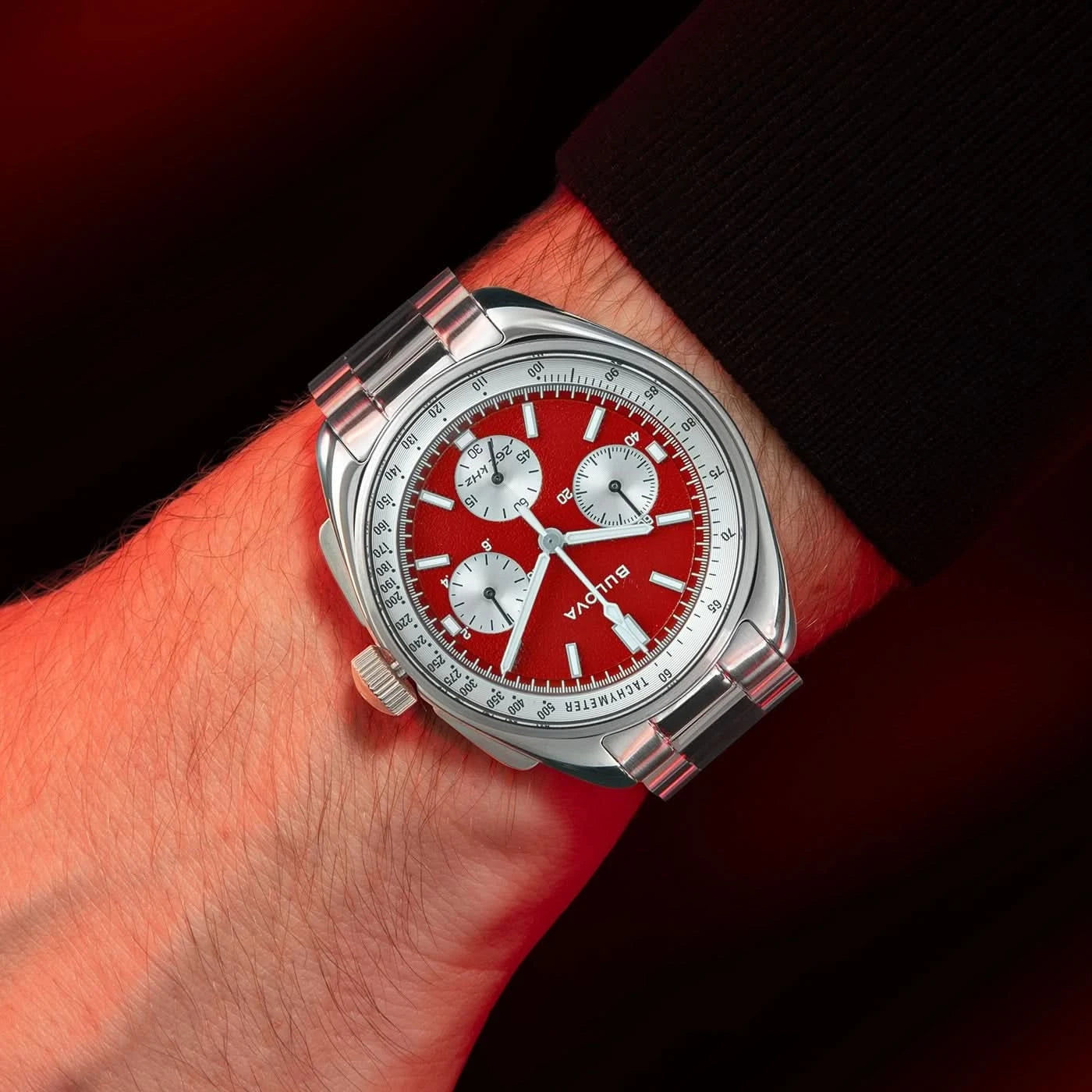 Herrklocka Bulova på handleden, röd urtavla och silverfärsat metallhölje