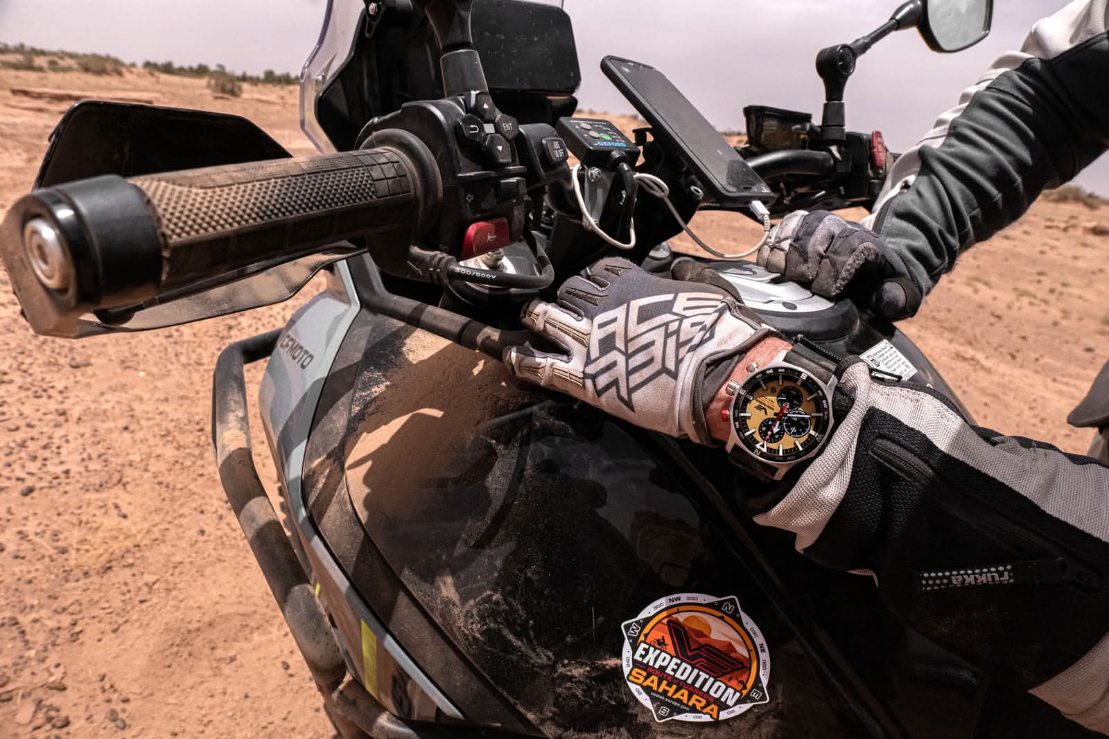 Vostok Europe herrarmbandsur på motorcykelinstrumentbräda med svart urtavla och gulddetaljer