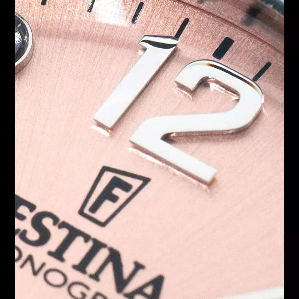 Festina del i rostfritt stål med F-logotyp och gravyr, närbild
