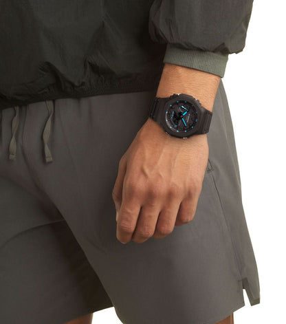 Herrklocka med svart armband runt handleden, svart urtavla med blå markörer