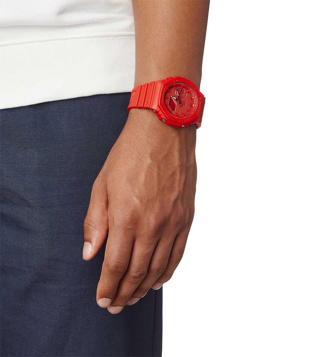 Rött herrur på handleden med boett i plast och silikonarmband