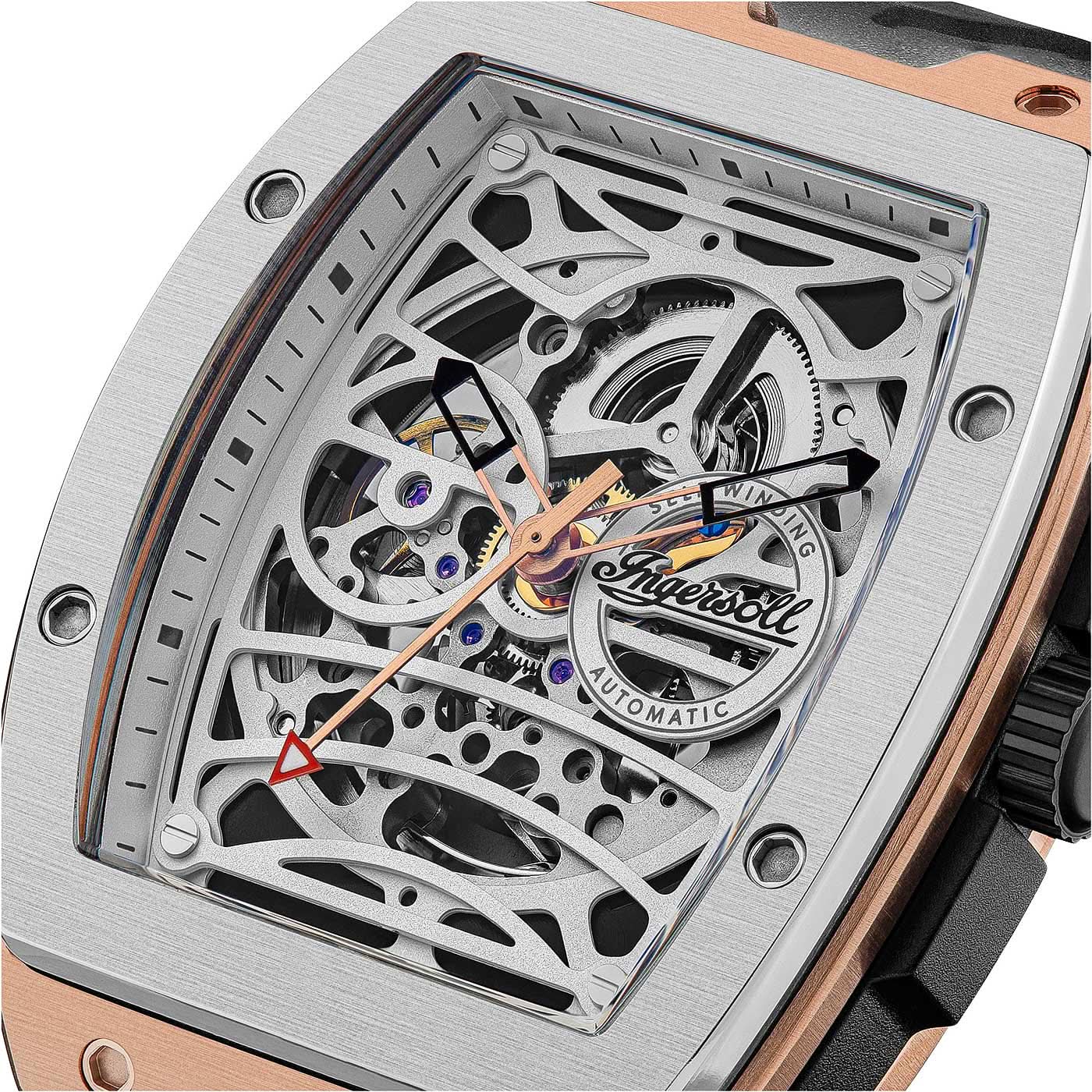 Nahaufnahme: Herrenuhr mit offenem Automatik-Mechanik-Zifferblatt, roségoldfarbenem Rahmen, schwarzem Band.