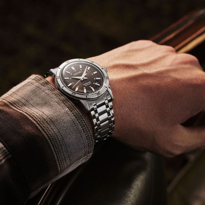 Seiko herrklocka på handleden med svart urtavla och armband i rostfritt stål