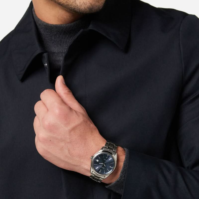 Armbandsur på handleden: blå urtavla och silverfärgat titanarmband