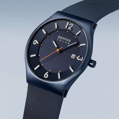 "Herrklocka med blå urtavla, orange accenter och mesh-armband i metall"
