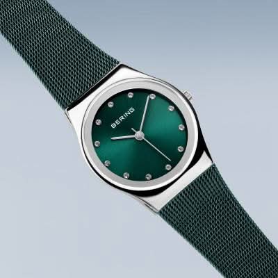 "Damklocka med grön urtavla, silverfärgade visare och grönt milanesarmband"