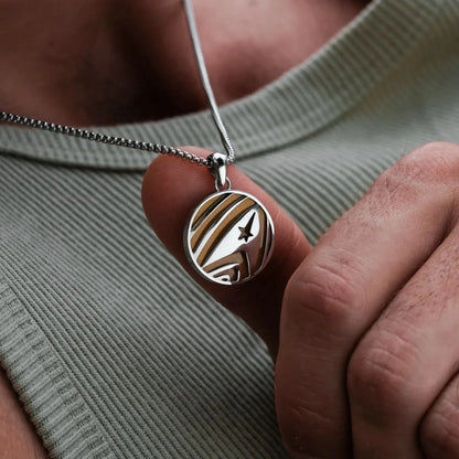 "Halsband med rundt silverhänge och guldfärgade ränder, stjärnmotiv"