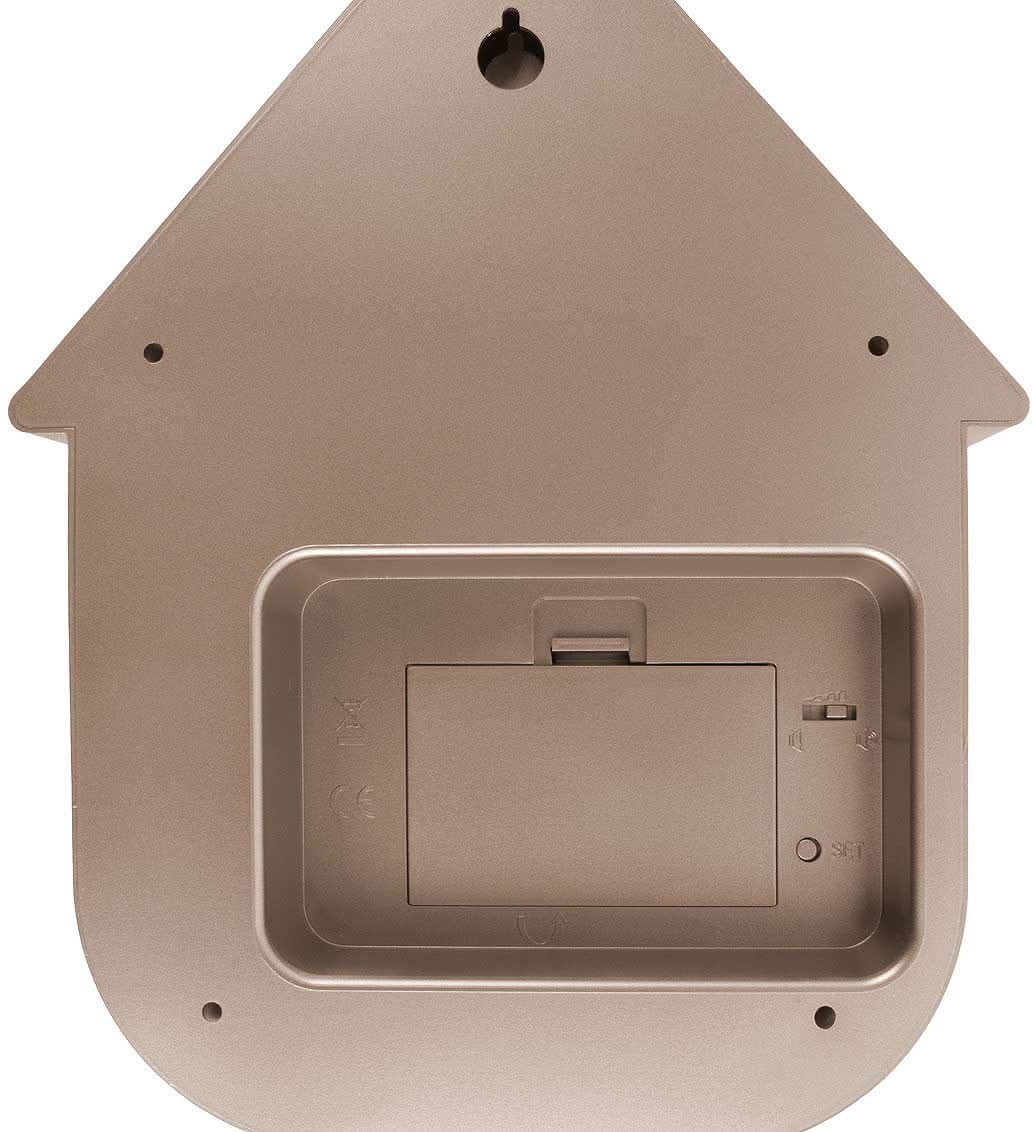 Väggklocka i husdesign av plast, beige, interiörvy med urverk i höljet