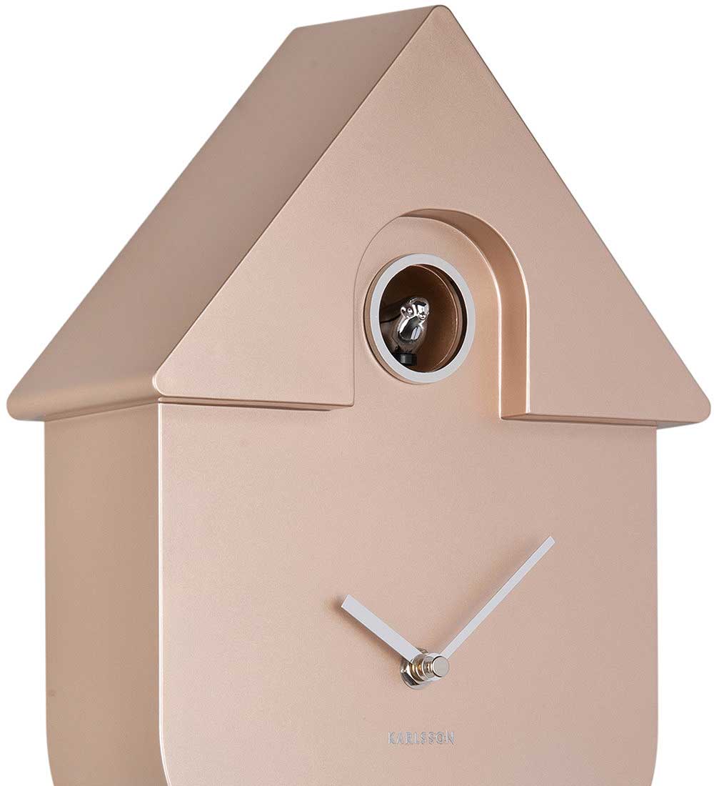 beige plastväggklocka i husdesign, framifrån med runt fönster och visare
